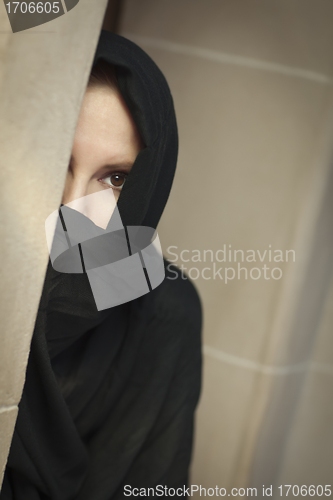 Image of Cautious Islamic Woman in Window Pane Wearing Burqa or Niqab