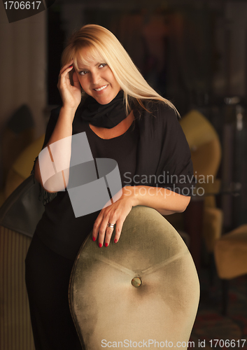 Image of Beautiful Blonde Woman Standing Near Chair