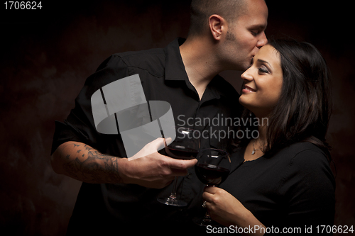 Image of Happy Mixed Race Couple Flirting and Holding Wine Glasses
