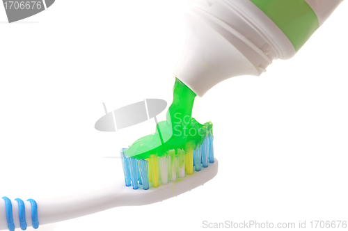 Image of Toothpaste coming out of a tube on Toothbrush on white background