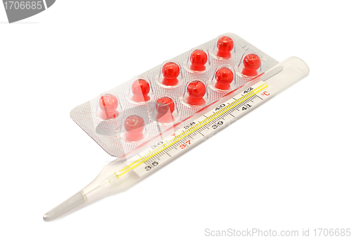 Image of Pills Vitamin E capsules and thermometer on white background