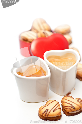 Image of heart shaped cream cookies on red heart metal box and coffee