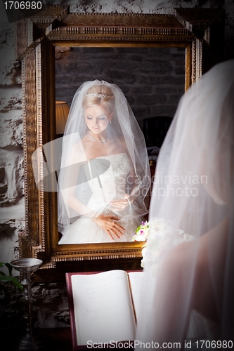 Image of beautiful bride in white infront of mirror