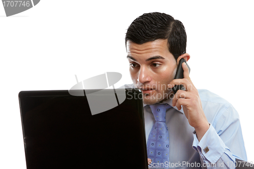 Image of Man at computer making or receiving phone call