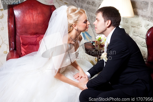 Image of beautiful groom and bride kissing in old interior
