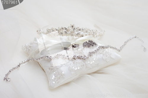 Image of personal accessories of bride on white pillow