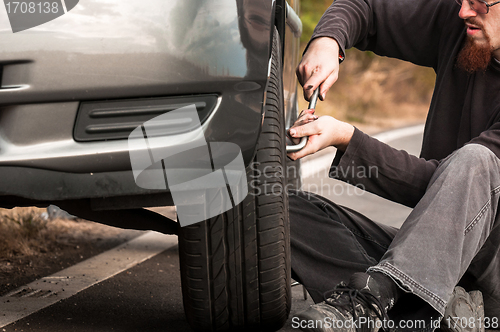 Image of Young man repairing car