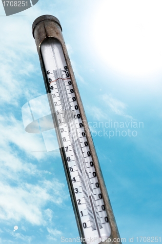 Image of Old thermometer against blue sky