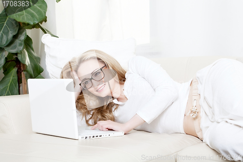 Image of young blonde woman on couch with notebook