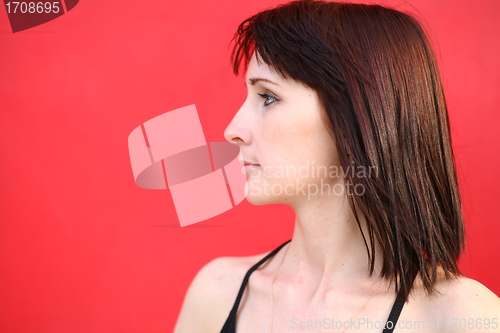 Image of girl is posing against red wall