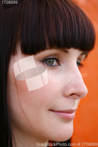 Image of girl is posing against orange wall