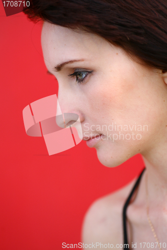 Image of girl is posing against red wall