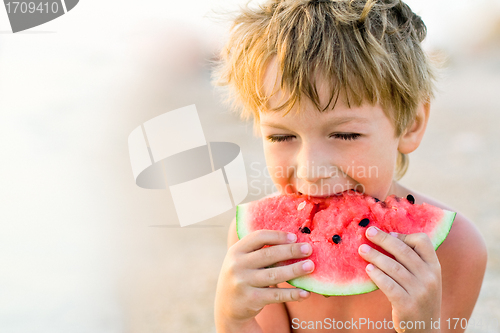 Image of boy taking a bite of watermelon