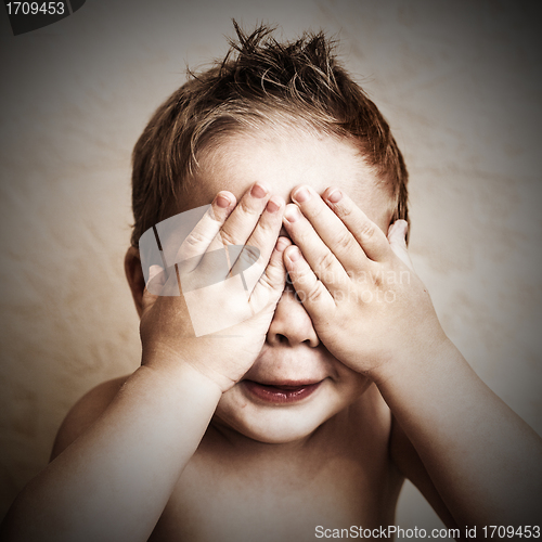 Image of Portrait of little boy closed eyes with his hands