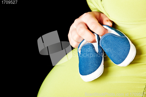 Image of pregnant woman with baby shoes