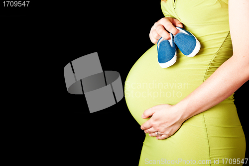 Image of pregnant woman with baby shoes