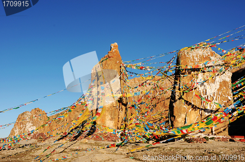 Image of Huge rocks wrapped with colorful prayer flags