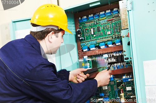 Image of Electrician checking current at power line box