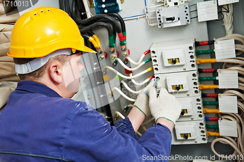 Image of Electrician tighten the screws with spanner