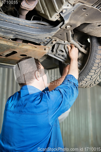 Image of auto mechanic at car suspension repair work