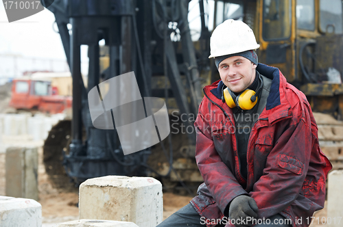 Image of builder in dirty workwear at construction site