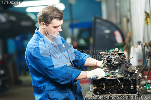 Image of auto mechanic at repair work with engine