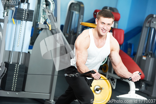 Image of bodybuilder man doing exercises in fitness club