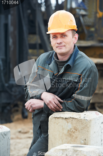 Image of builder in dirty workwear at construction site