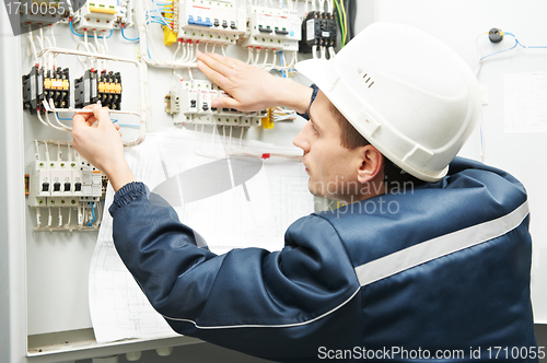 Image of Electrician with drawing at power line box