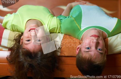 Image of Two smiling kids lying in bed