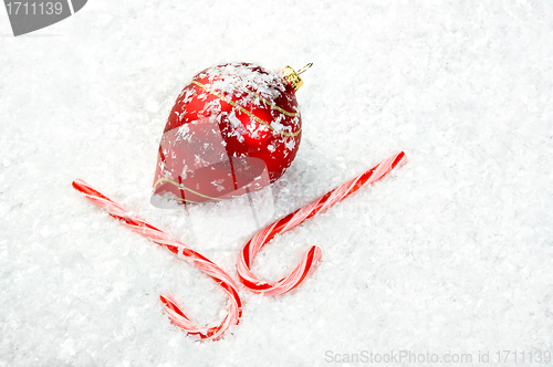 Image of Candy Canes and Ornament lying in the snow