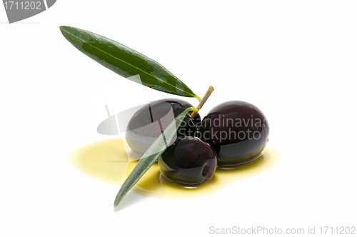 Image of three fresh olives bathed in olive oil