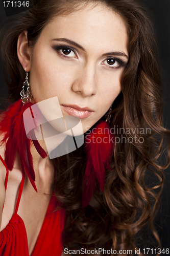 Image of woman in red dress with long curly hair on black background
