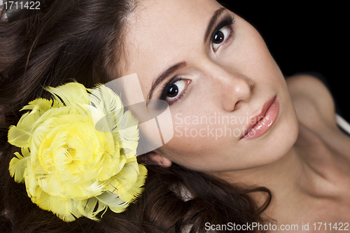 Image of Pretty women on black background wearing yellow feathers