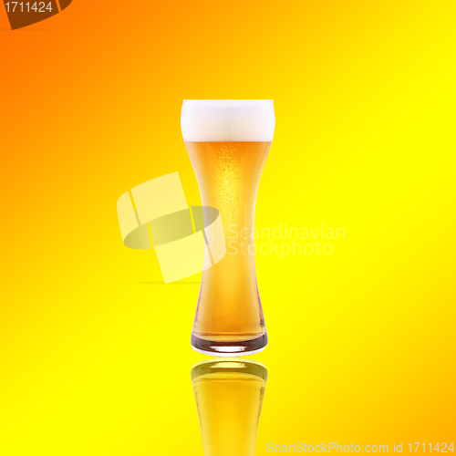 Image of Beer glass with froth over yellow background