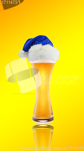 Image of Beer and hat of Santa Claus on a yellow background