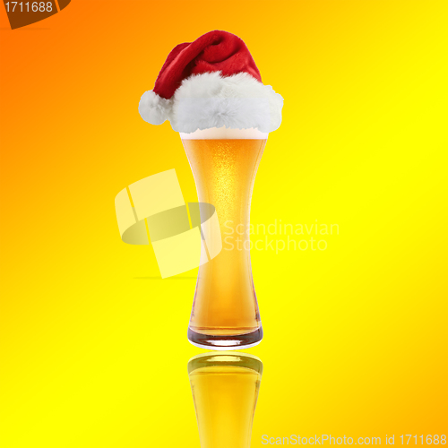 Image of Santa Claus hat with beer on a yellow background