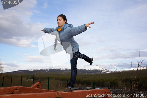 Image of girl doing gymnastic element of the balance on a log