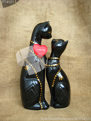 Image of Two toy enamoured cats on a brown background