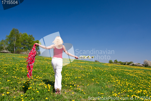Image of young woman with a red scarf on a meadow