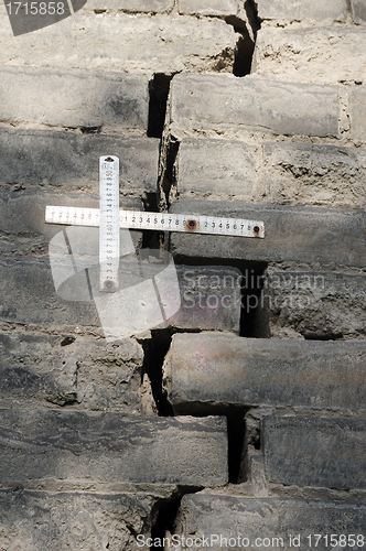 Image of Rulers measuring the cracks in the brick wall