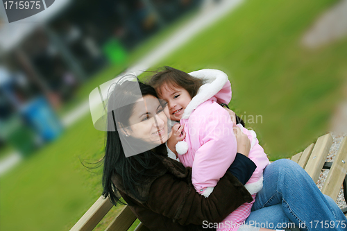 Image of Diverse mom and daughter sitting in the bench