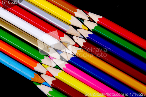 Image of Assortment of coloured pencils with shadow on white/back backgro