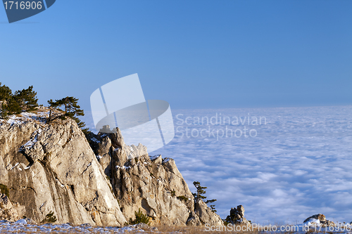 Image of Sunlit cliffs and sea in clouds