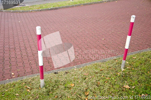 Image of tiled park lane and protective barrier stakes 