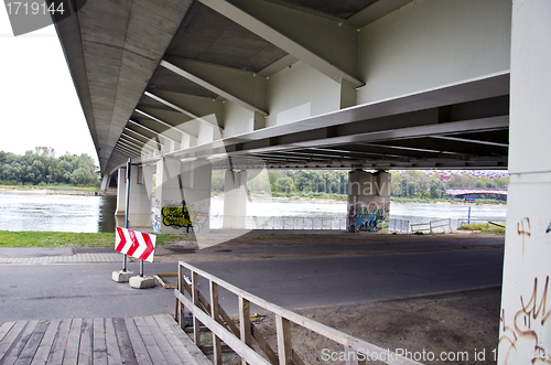 Image of road sign direction under large river bridge 