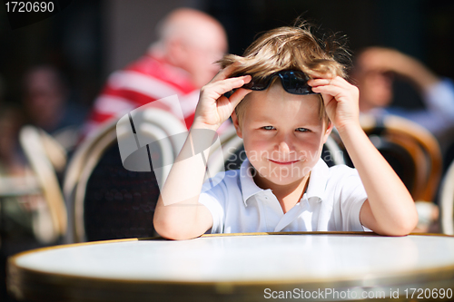 Image of Boy sitting in outdoor restaurant