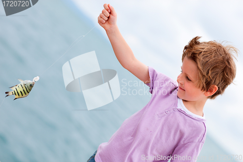 Image of Boy holding caught fish