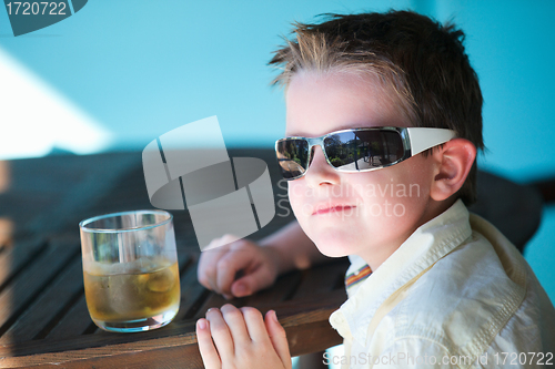 Image of Stylish little boy drinking juice