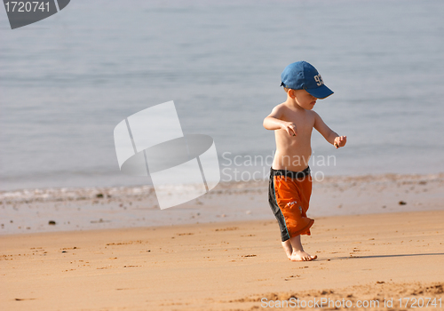 Image of Small boy playing at sandy beach